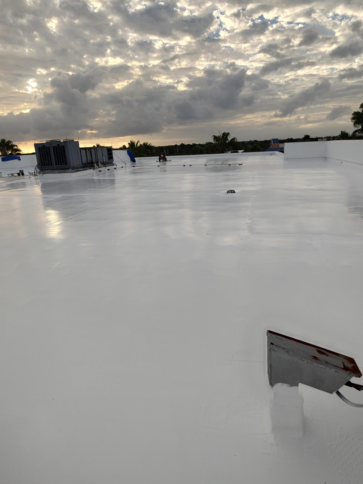 White silicone roof coating on commercial facility